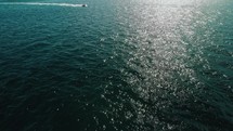 drone films fast boat at a lighthouse in the ocean