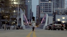 a woman walking across a city bridge 