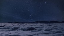 Starry night sky with milky way stars motion over wild foggy mountains nature landscape in Epic blue Astronomy time-lapse

