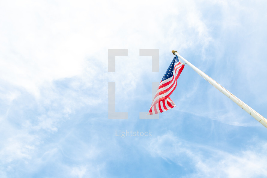 American flag flying high against blue sky