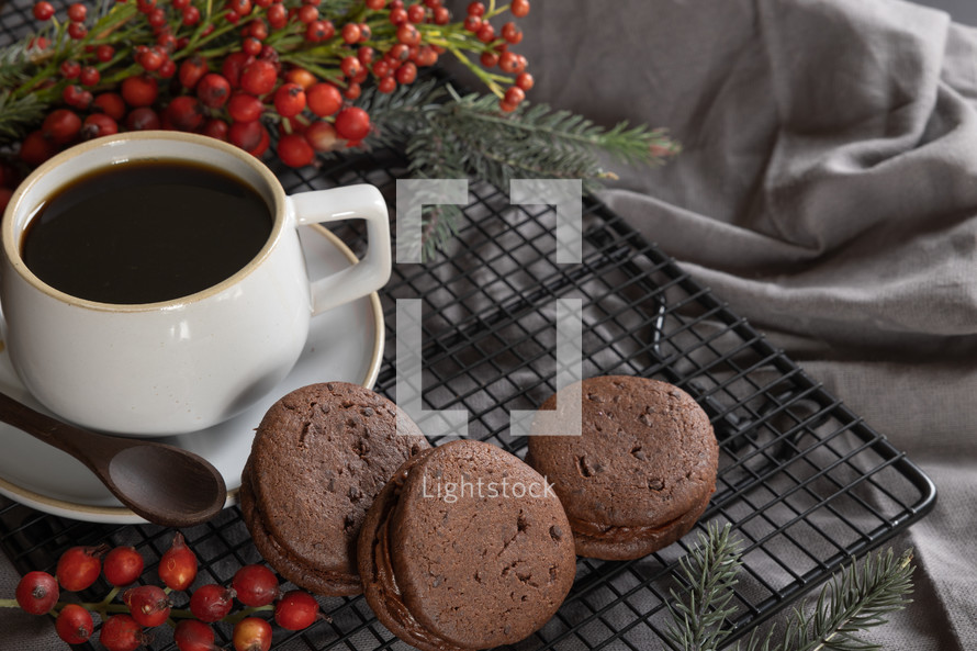 chocolate sandwich cookies and coffee, red berries 