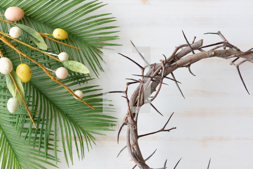 Easter eggs, palm fronds, and crown of thorns on a white background 