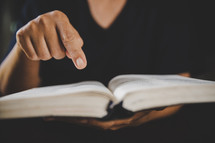 Hands holding a Bible and pointing