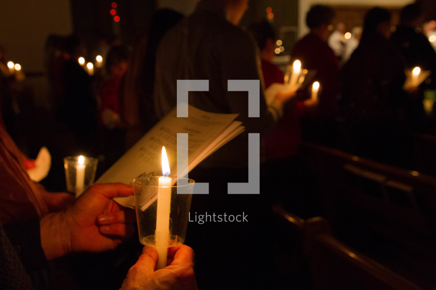 people in a congregation at a Christmas Eve candlelight service
