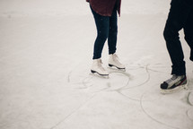 a man and woman skating on the ice 