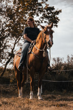 Horse riding woman on a brown stallion, western style saddle horseback rider