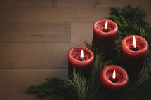 Red candles on wood with garland