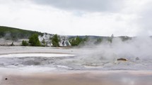 Yellowstone , Montana , United States - April 2022: Tourists walking through geysers of Yellowstone National Park in slow motion.
