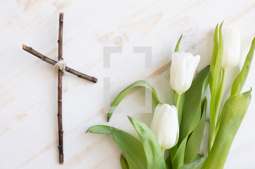 cross of sticks and white tulips 