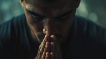 A man praying with his hands closed together