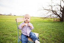 toddler boy sitting on a chair 