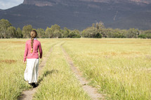 teen girl walking in a field 