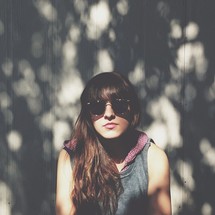 a woman in sunglasses with long brunette hair 