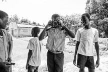 children and youth with a camera in a village 