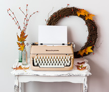 blank paper in a typewriter and fall decorations 