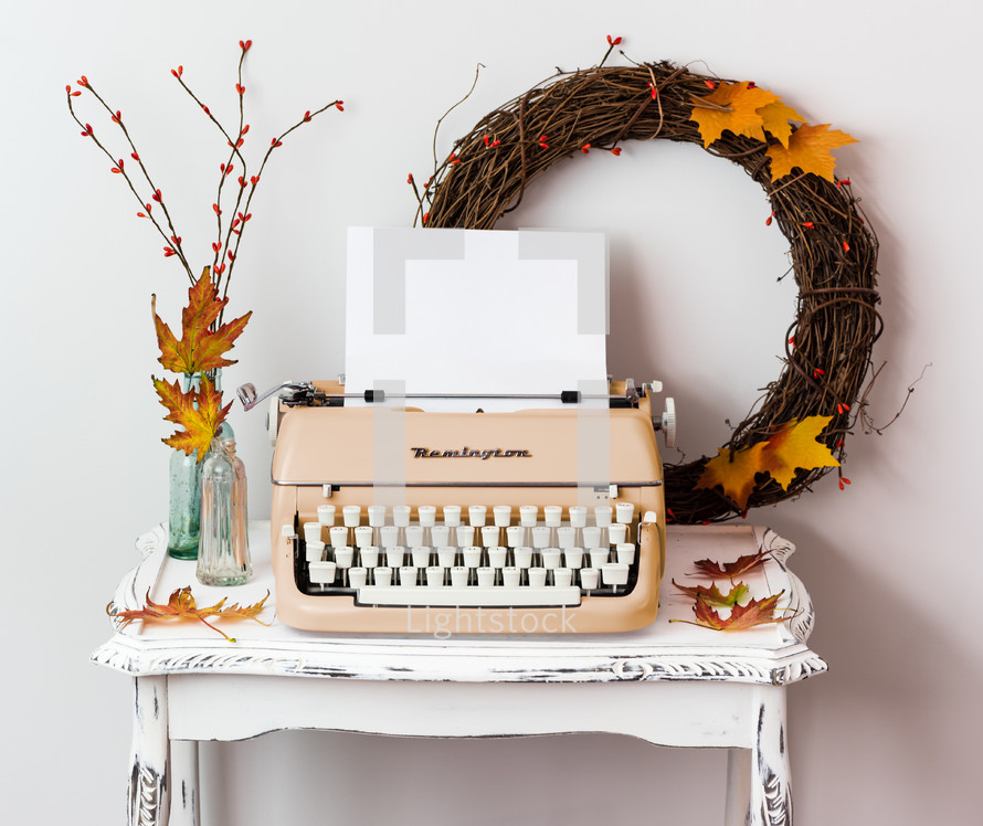 blank paper in a typewriter and fall decorations 