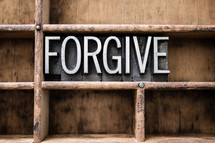 word forgive in blocks on a bookshelf 
