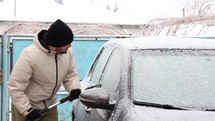 Man Scraping Frost Off The Car Window During Winter. medium shot
