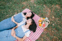 girls lying on a picnic blanket 