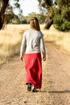 Girl Walking Down Dirt Road