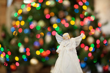 angel ornament in front of bokeh Christmas lights 
