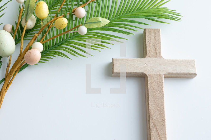 Palm branch with Easter egg decoration and wooden cross