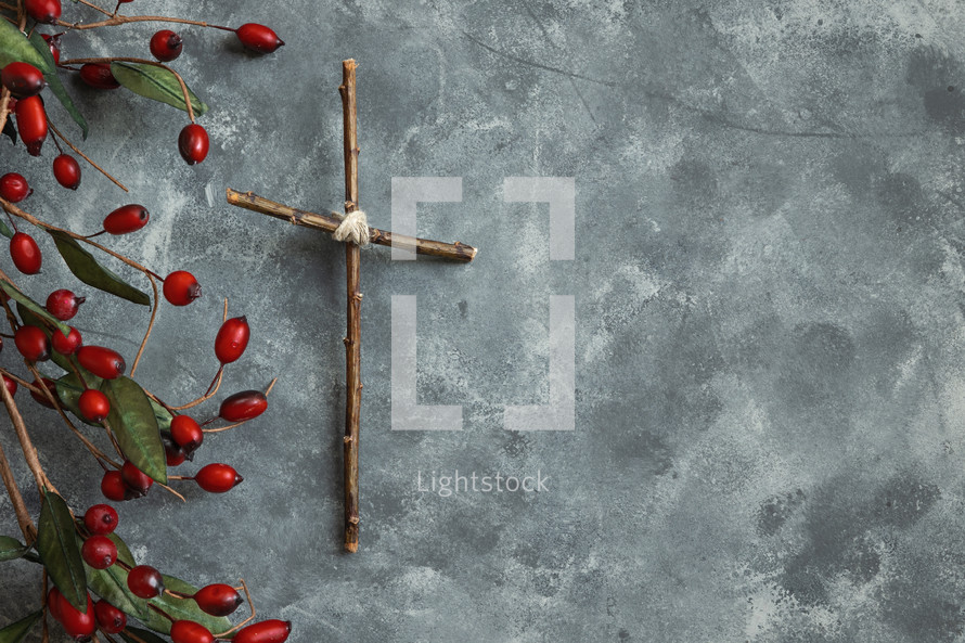 cross and red berries on gray