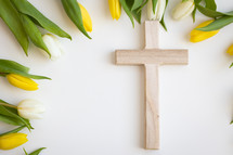 Cross framed by yellow and white tulips on a white background