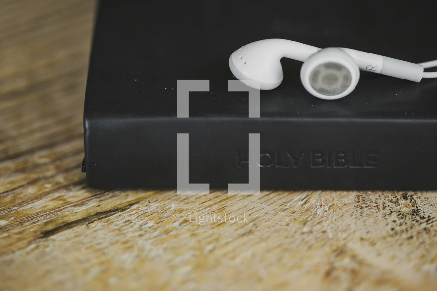 White ear buds on a Bible.