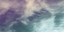 feathery clouds - dreamy purple and green sky background 