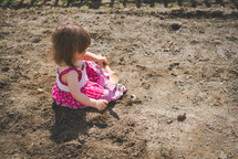 a little girl playing in dirt 