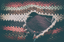 hole torn into a knit blanket 
