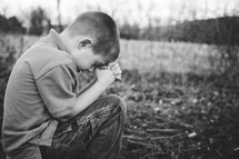 boy child with head bowed in prayer 