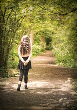 a teen girl walking down a path