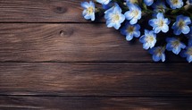 Beautiful blue flowers on a wooden background. Place for text.