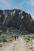 people walking on a nature trail in desert mountains 