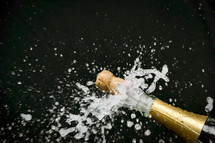 popping the cork of a champagne bottle 