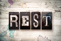 word rest on a white wash wood background 