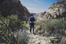 man walking on a nature trail in a desert