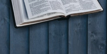 opened Bible on gray wood background 