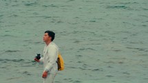 Asian man taking pictures around the sea
