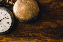 pocket watches on a wood table 