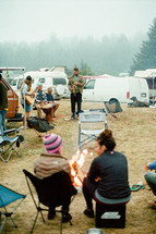 people sitting around a campfire at an outdoor festival 