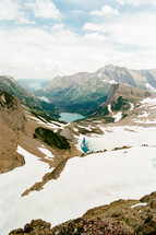 snow on a mountain and a turquoise pond 