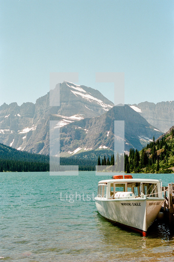 boat tied to a dock and view of a mountain 