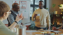 Black Student Reciting Lesson with Word Cards in Immigrant Language School
