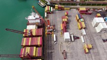 Containers are unloading from the ship in the port