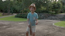 Young boy throwing paper airplane around outdoors in park