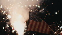 fireworks on the ground at night and American flag