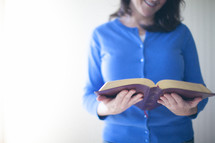 smiling woman reading a Bible